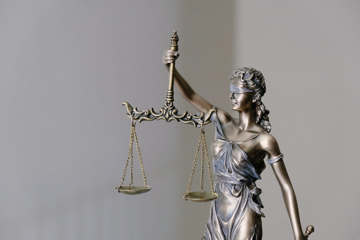Statue d'une femme aux yeux bandés tenant d'une main un glaive et de l'autre une balance